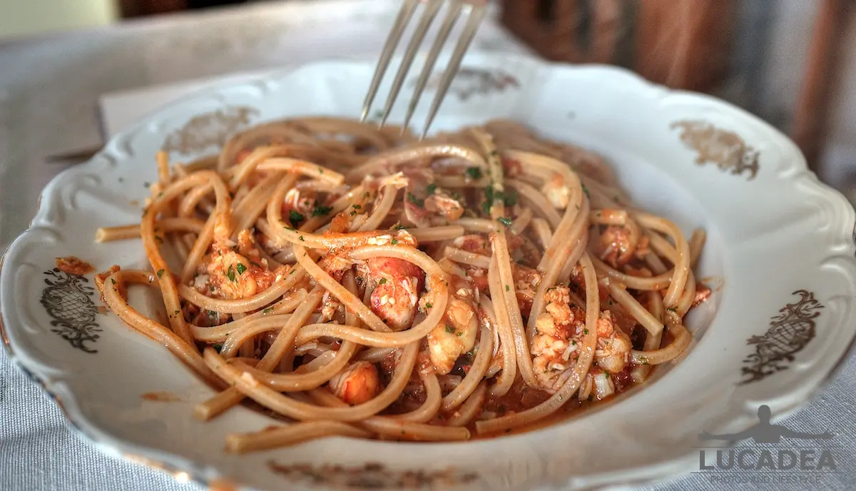 Trenette integrali al sugo di astice fresco servite in un piatto di cucina di mare