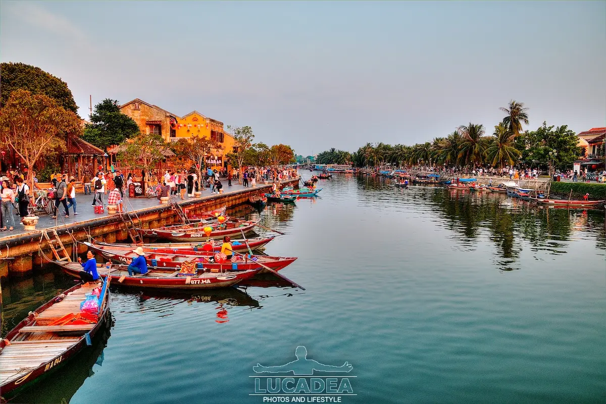 Tramonto a Hoi An in Vietnam con barche sul fiume e luci calde vicino alla città storica