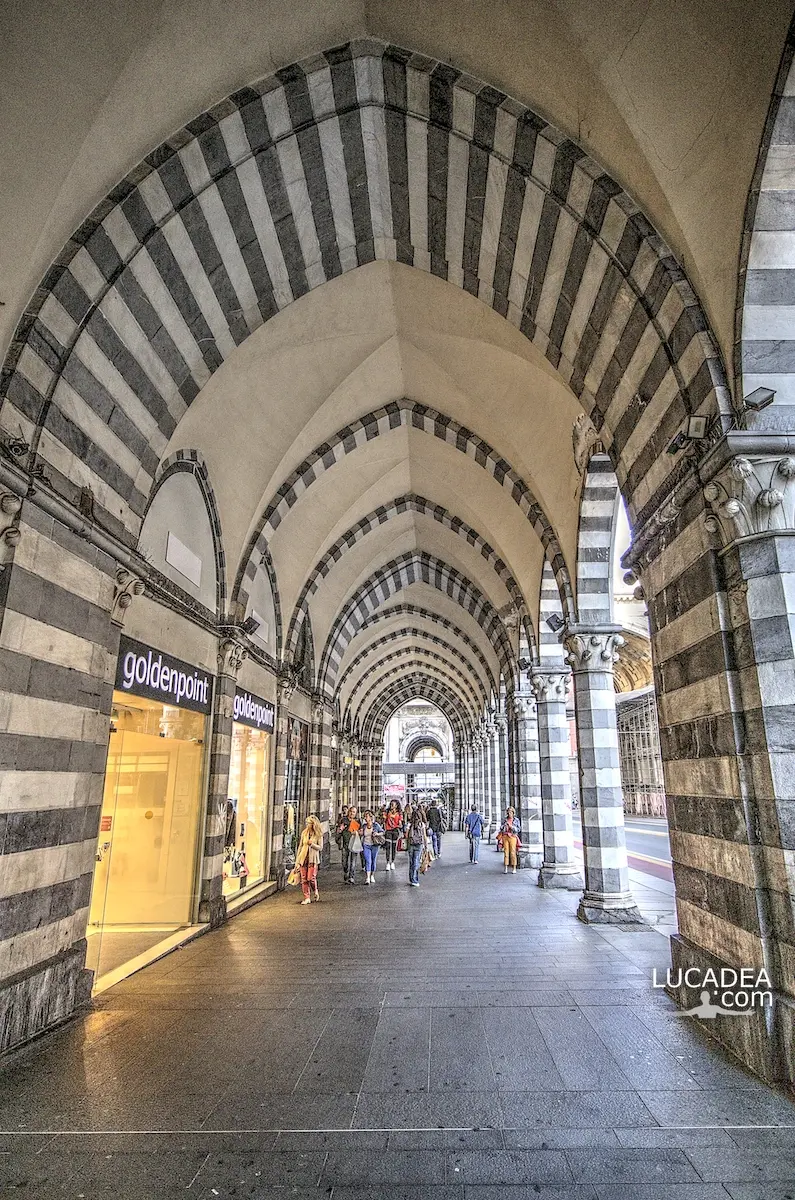 Portici di via XX Settembre nel centro di Genova, con colonne e archi decorati in pietra bianca e nera