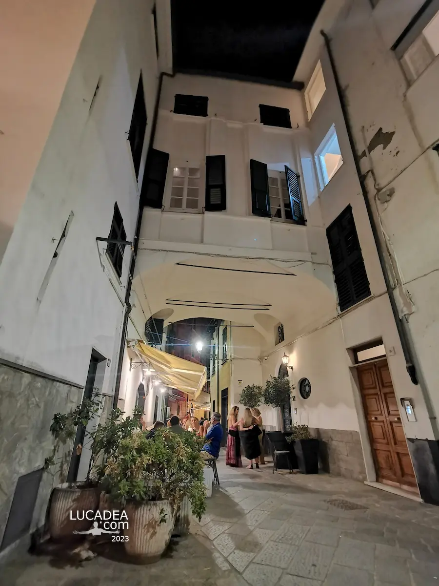 Archivolto di via Garibaldi a Sestri Levante con tavoli di un ristorante durante la vita notturna estiva