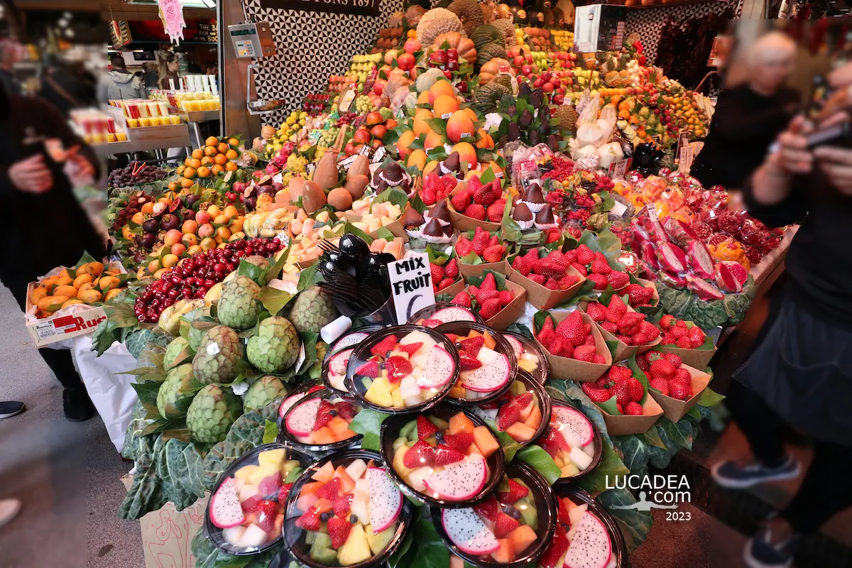Fresh fruit displayed at La Boqueria in Barcelona, with mango, dragonfruit, strawberries and other produce