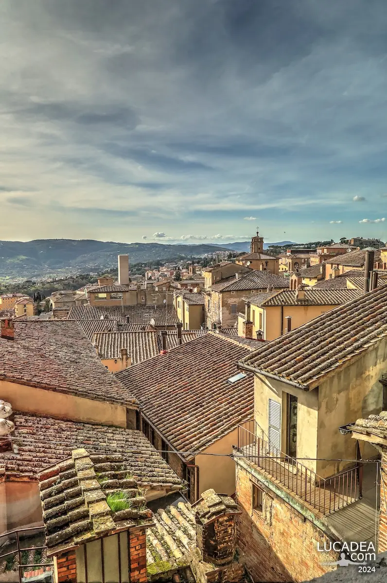 Vista sui tetti di Perugia dal centro storico con edifici medievali, campanili e panorami dell'Umbria