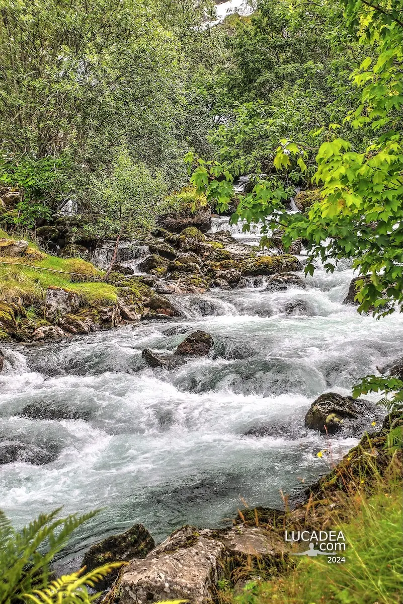 Cascata Kleivafossen a Geiranger, tra roccia e vegetazione, con l'acqua che scende verso il fiordo