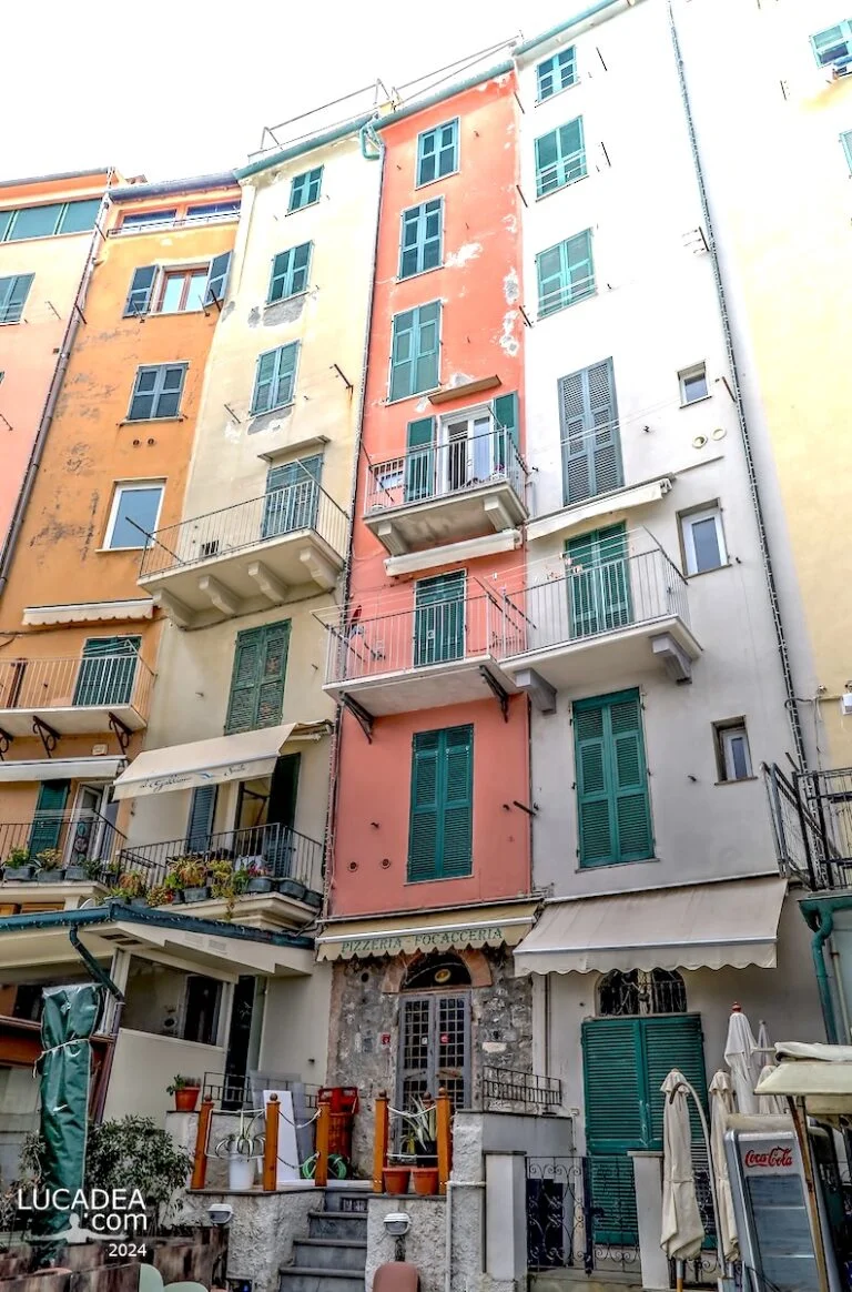Case alte e strette colorate di Portovenere affacciate sul mare, vicine tra loro con facciate verticali lungo la costa ligure