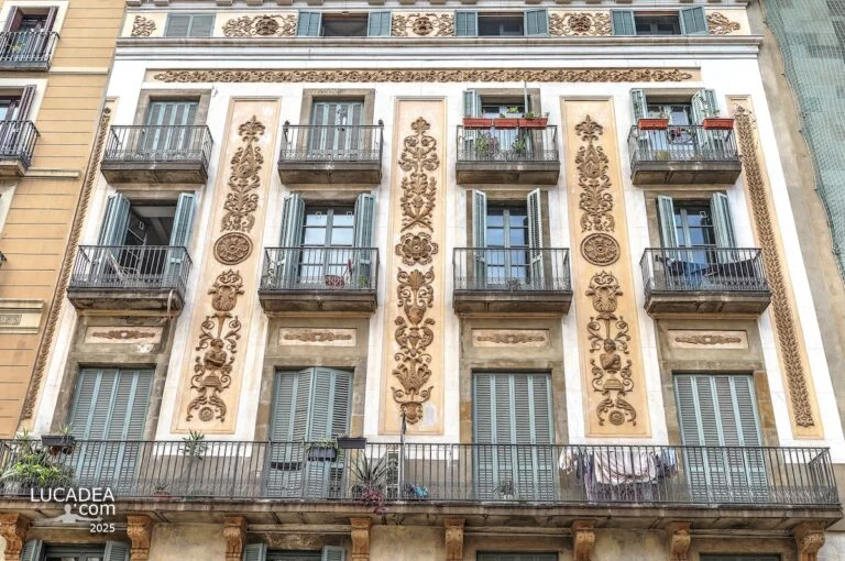 Facciata decorata di un palazzo sulla Rambla di Barcellona con balconi, persiane verdi e dettagli architettonici in rilievo