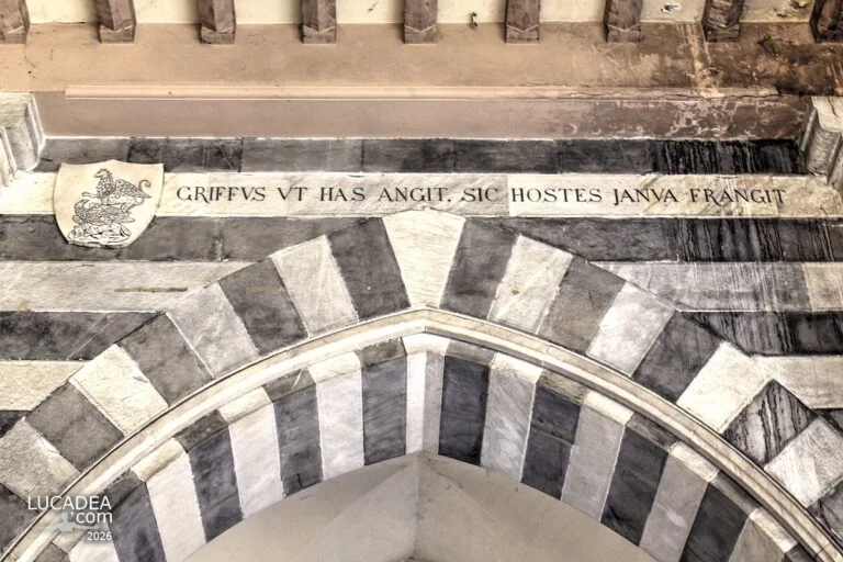 Dettaglio dell’arco marmoreo a Genova con iscrizione latina di Genova e stemma del grifone scolpito nella pietra storica