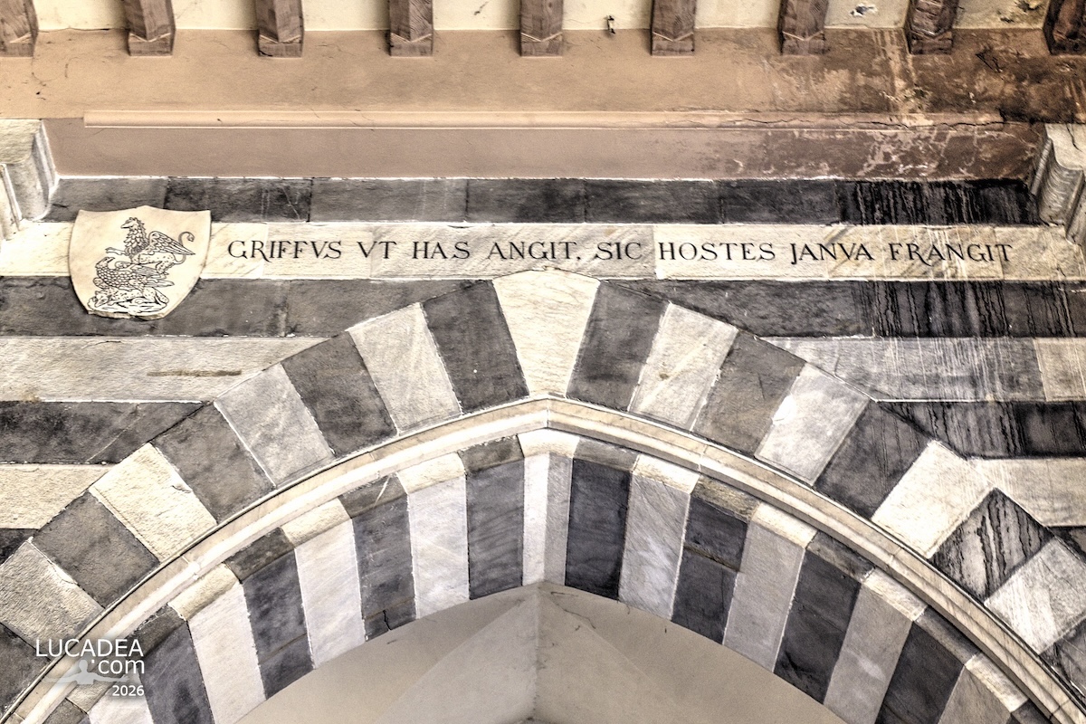 Dettaglio dell’arco marmoreo a Genova con iscrizione latina di Genova e stemma del grifone scolpito nella pietra storica