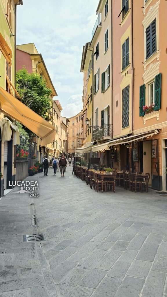 Caruggio di Sestri Levante con fiori rossi e palazzi colorati nel centro storico ligure tra vicoli suggestivi