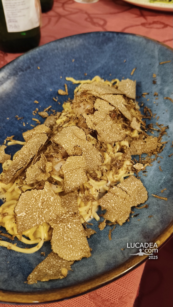 Tagliolini al tartufo in centro a Sestri Levante su piatto blu con scaglie di tartufo, atmosfera di ristorante nel borgo ligure