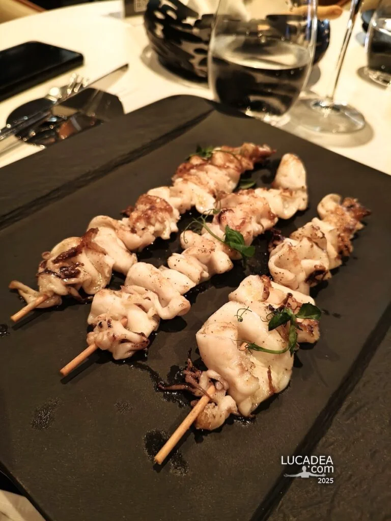 Spiedini di calamari al Ferrai bar sulla Costa Toscana, un piatto di mare fotografato durante una pausa in crociera.