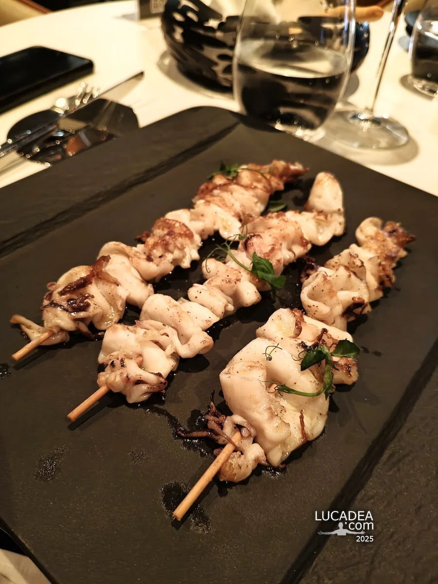 Spiedini di calamari al Ferrai bar sulla Costa Toscana, un piatto di mare fotografato durante una pausa in crociera.